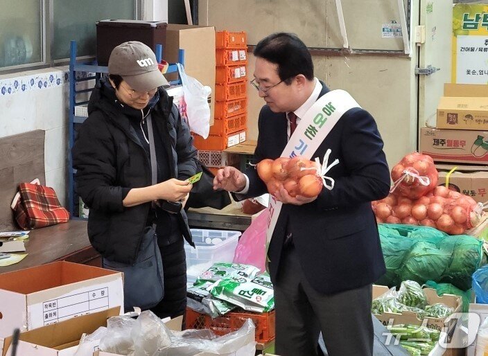 본문 이미지 - 27일 황규철 옥천군수가 옥천공설시장에서 농어촌 기본소득  향수OK카드로 농산물을 구입하고 있다. (재판매 및 DB금지)