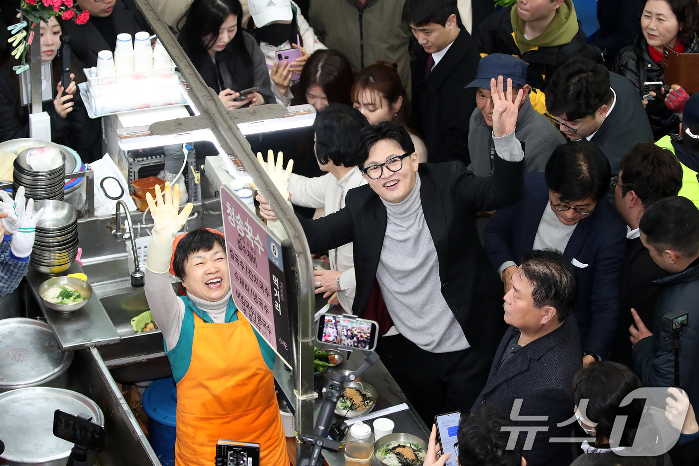 (대구=뉴스1) 공정식 기자 = 한동훈 전 국민의힘 대표가 27일 오후 대구 중구 서문시장 국수골목을 찾아 상인과 함께 손을 흔들고 있다. 2026.2.27/뉴스1