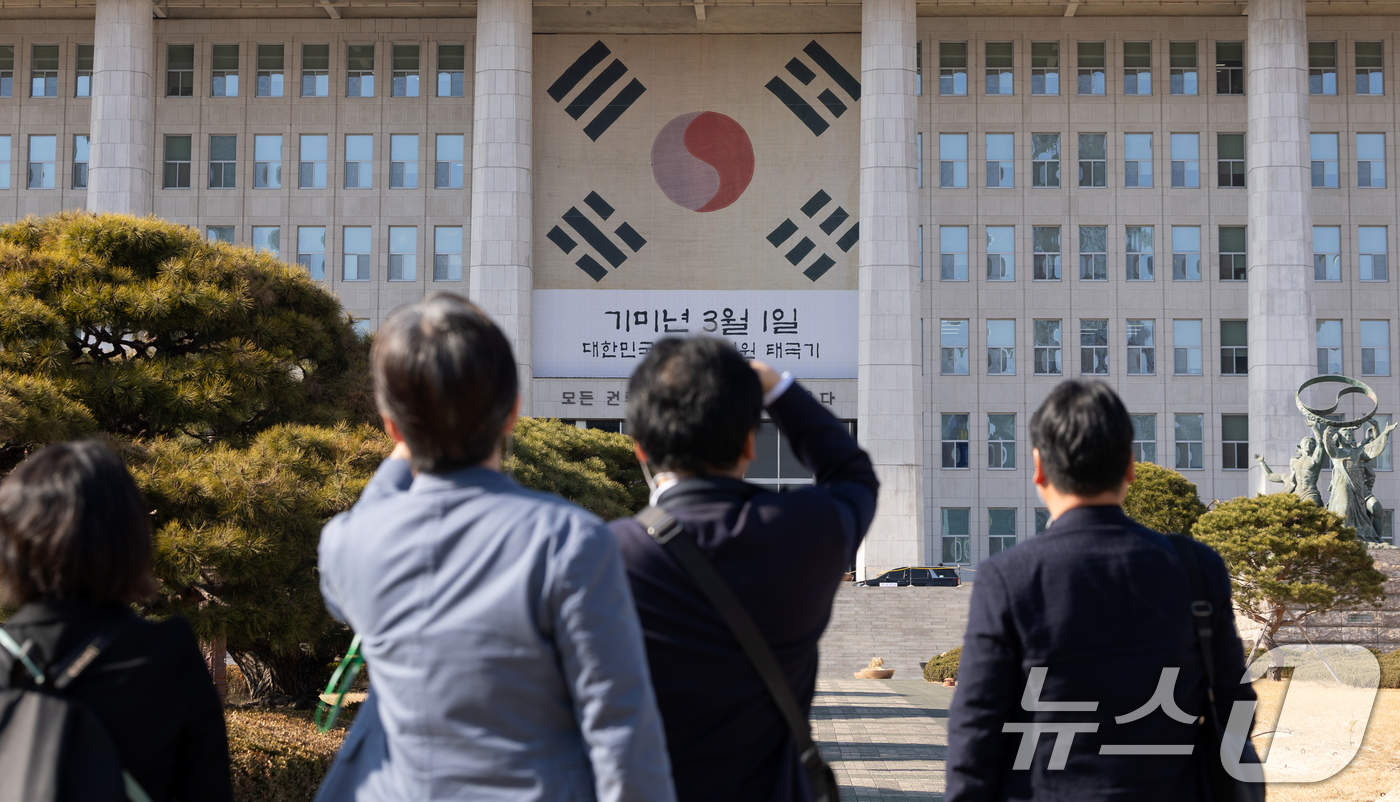 (서울=뉴스1) 이승배 기자 = 3.1절을 앞둔 27일 서울 여의도 국회에서 한국을 방문한 일본인들이 본청 건물에 걸린 대한민국 임시의정원 태극기를 보고 있다. 2026.2.27/ …