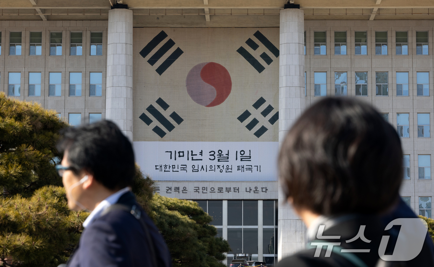 (서울=뉴스1) 이승배 기자 = 3.1절을 앞둔 27일 서울 여의도 국회에서 한국을 방문한 일본인들이 본청 건물에 걸린 대한민국 임시의정원 태극기를 보고 있다. 2026.2.27/ …