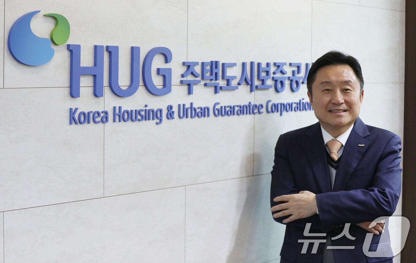 본문 이미지 - 최인호 HUG 사장이 부산 남구 HUG 본사에서 뉴스1과 인터뷰를 마친 뒤 HUG 로고 앞에서 포즈를 취하고 있다. 2026.2.27 ⓒ 뉴스1 윤일지 기자
