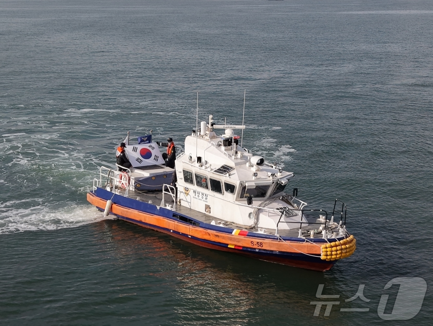 (보령=뉴스1) 최형욱 기자 = 지난 26일 오전 충남 보령 대천항 앞바다에서 대천파출소 연안 구조정에 탑승 중인 보령해경 직원들이 3.1절을 앞두고 태극기를 펼치며 항해하고 있다 …