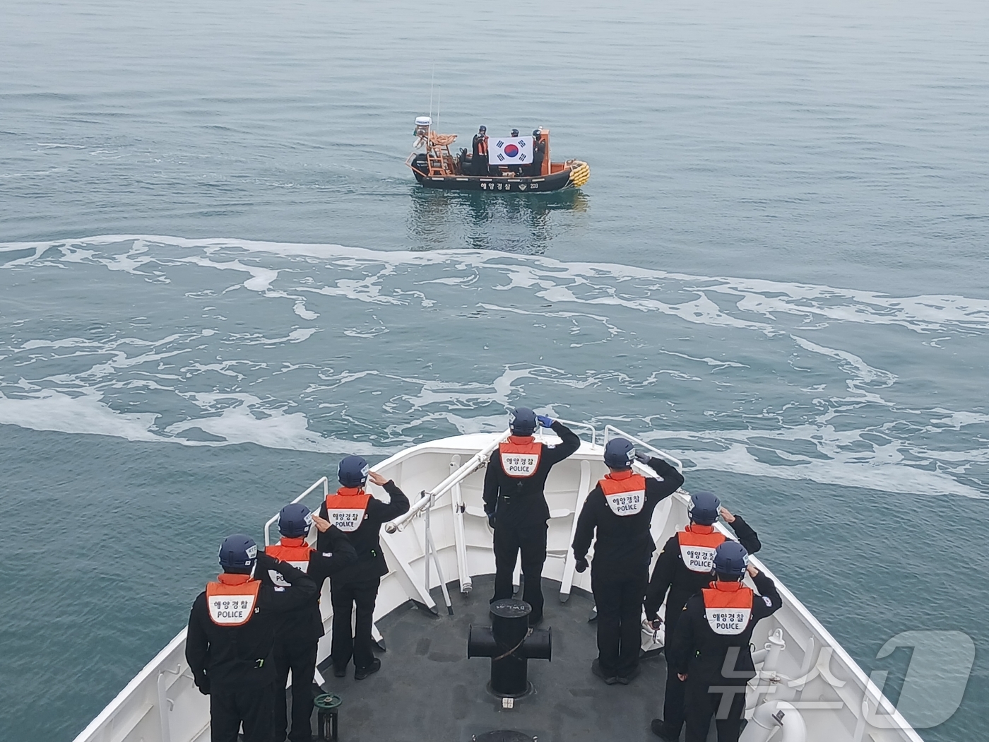 (보령=뉴스1) 최형욱 기자 = 지난 26일 오전 충남 보령 오천면 외연도 인근 해상에서 경비함정에 탑승한 보령해양경찰서 직원들이 고속단정에 놓여있는 태극기에 경례를 하고 있다. …
