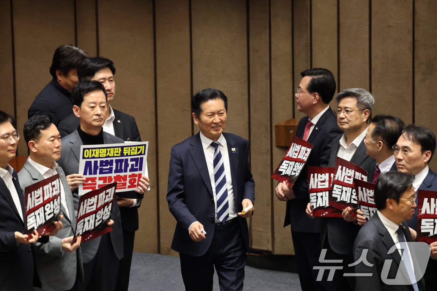 본문 이미지 - 27일 서울 여의도 국회에서 열린 제432회 국회(임시회) 제8차 본회의에서 재판소원제 도입을 골자로 하는 헌법재판소법 일부개정법률안(대안)에 대한 무제한토론 종결 투표가 진행되는 가운데 정청래 더불어민주당 대표가 사법 3법과 관련 규탄 피켓 농성하는 국민의힘 의원들을 지나고 있다. 2026.2.27 ⓒ 뉴스1 이승배 기자