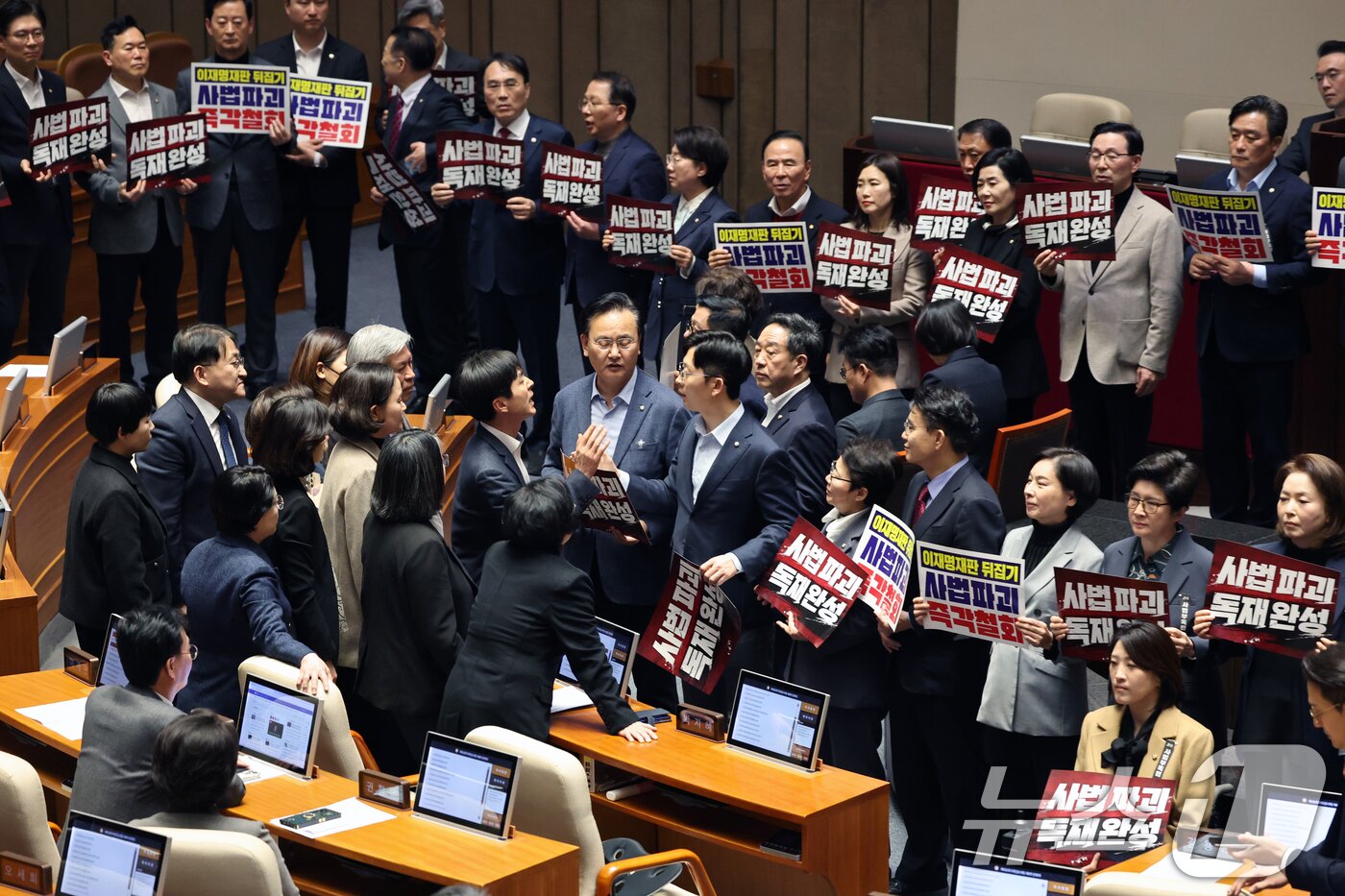 본문 이미지 - 27일 서울 여의도 국회에서 열린 제432회 국회(임시회) 제8차 본회의에서 국민의힘 의원들이 사법 3법 관련 규탄 피켓을 들고 의장석 주위에서 농성하자 여야 의원들 간 고성이 오가고 있다. 2026.2.27 ⓒ 뉴스1 이승배 기자
