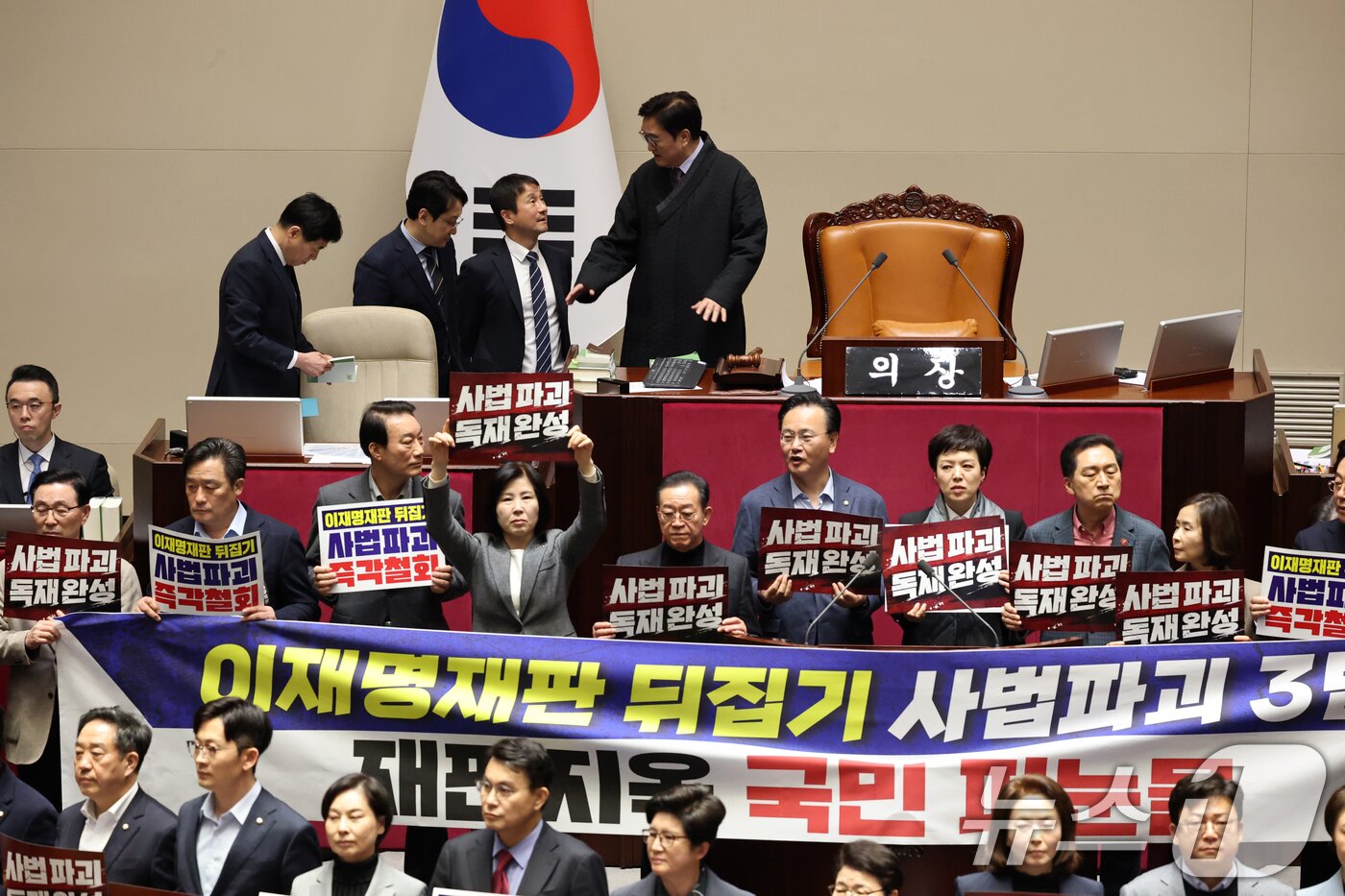 본문 이미지 - 27일 서울 여의도 국회에서 열린 제432회 국회(임시회) 제8차 본회의에서 국민의힘 의원들이 사법 3법 관련 규탄 피켓을 들고 의장석 주위에서 농성하는 가운데 한병도 더불어민주당 원내대표가 우원식 국회의장과 대화하고 있다. 2026.2.27 ⓒ 뉴스1 이승배 기자