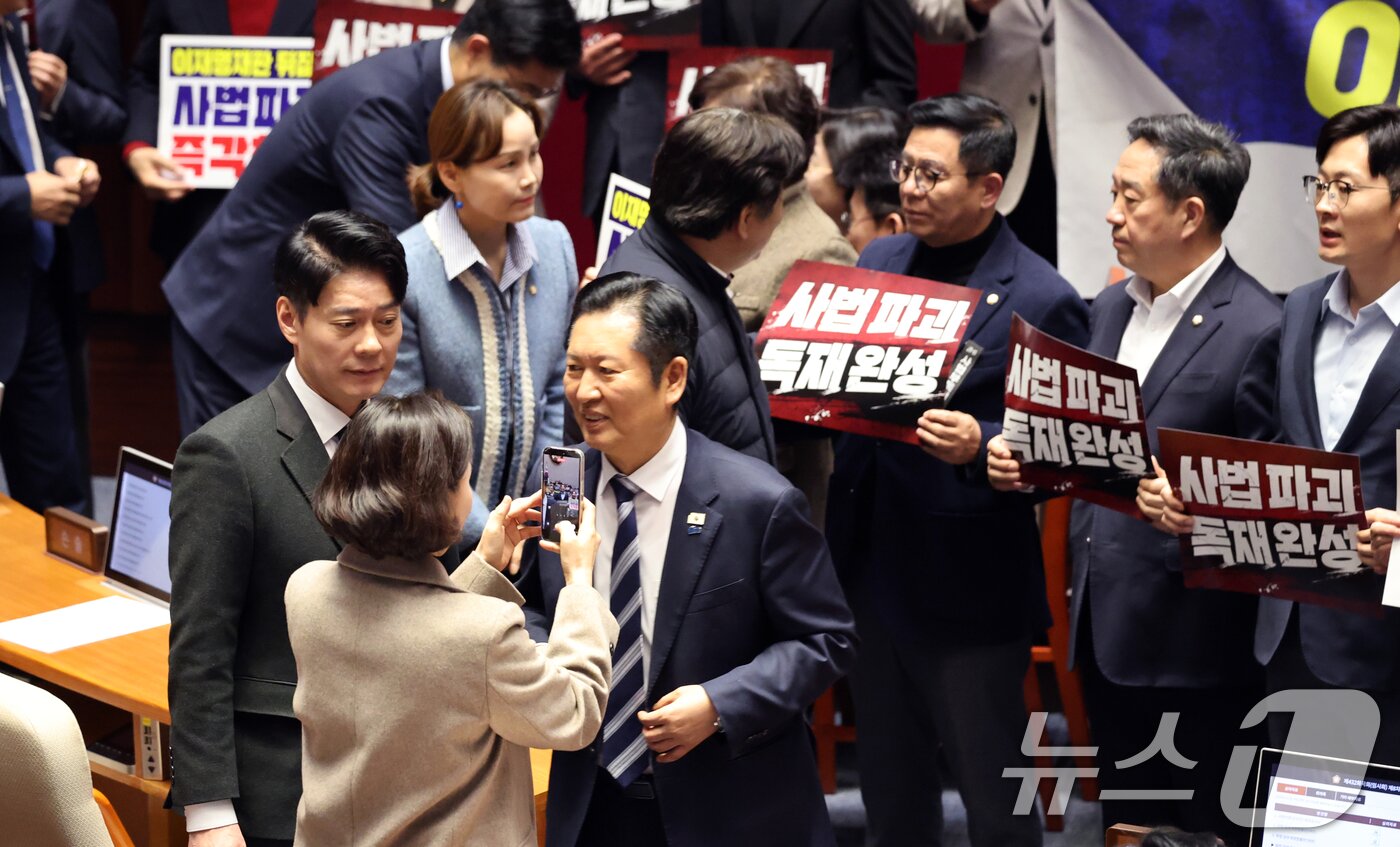 본문 이미지 - 27일 서울 여의도 국회에서 열린 제432회 국회(임시회) 제8차 본회의에서 재판소원제 도입을 골자로 하는 헌법재판소법 일부개정법률안(대안)에 대한 무제한토론 종결 투표가 진행되는 가운데 정청래 더불어민주당 대표가 사법 3법과 관련 규탄 피켓 농성하는 국민의힘 의원들을 지나고 있다. 2026.2.27 ⓒ 뉴스1 이승배 기자