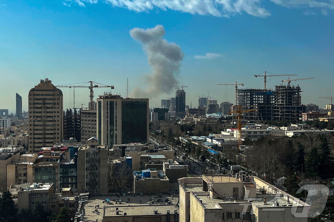 본문 이미지 - 28일(현지시간) 이란 수도 테헤란 도심에 연기 기둥이 솟아오르고 있다. 이스라엘 국방부는 이날 "이란에 대한 예방적 공격을 단행했다＂고 발표했다. ⓒ AFP=뉴스1