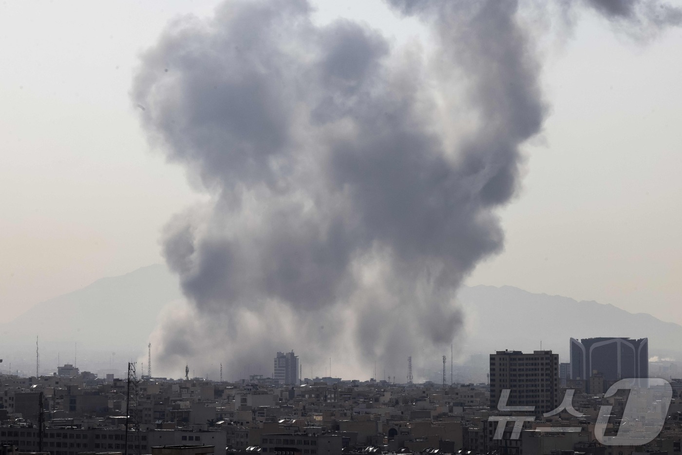(테헤란 AFP=뉴스1)  = 28일(현지시간) 이란 수도 테헤란 도심에 연기 기둥이 솟아오르고 있다. 이스라엘 국방부는 이날 "이란에 대한 예방적 공격을 단행했다"고 발표했다. …