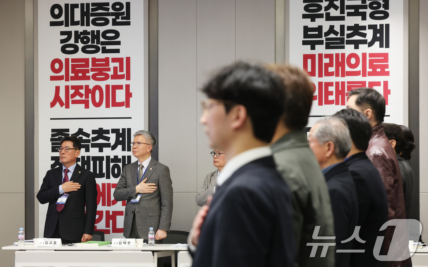 (서울=뉴스1) 오대일 기자 = 김택우 대한의사협회 회장(왼쪽 두번째)이 28일 오후 서울 용산구 대한의사협회 대강당에서 열린 2026년도 임시대의원총회에서 참석자들과 국기에 경레 …