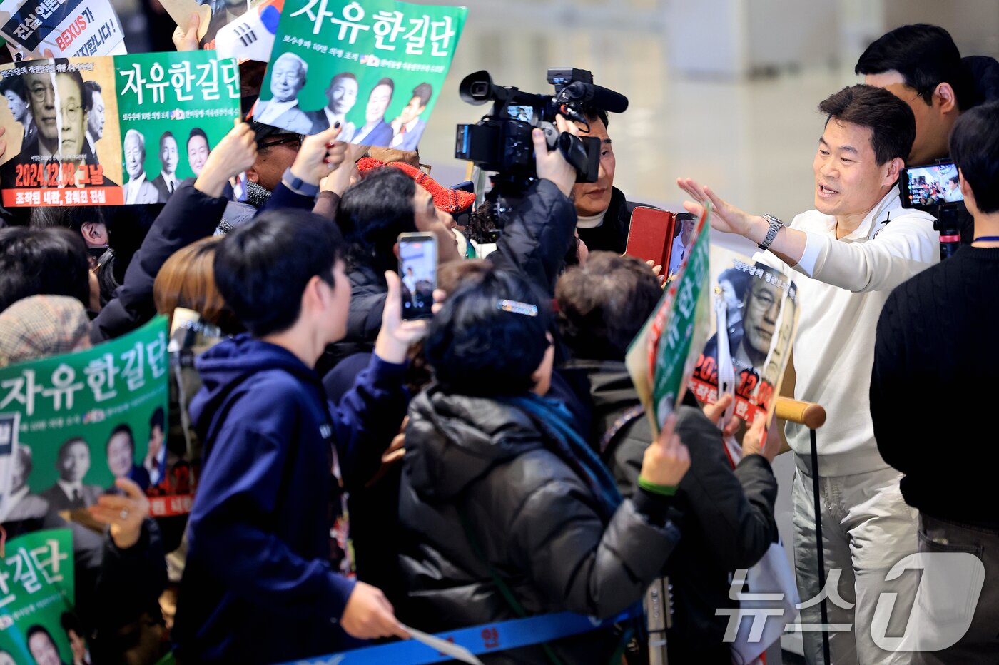 본문 이미지 - 전한길 전 한국사 강사가 3일 인천국제공항 제2여객터미널로 귀국해 지지자들을 향해 손을 흔들고 있다. 2026.2.3/뉴스1 ⓒ News1 이호윤 기자
