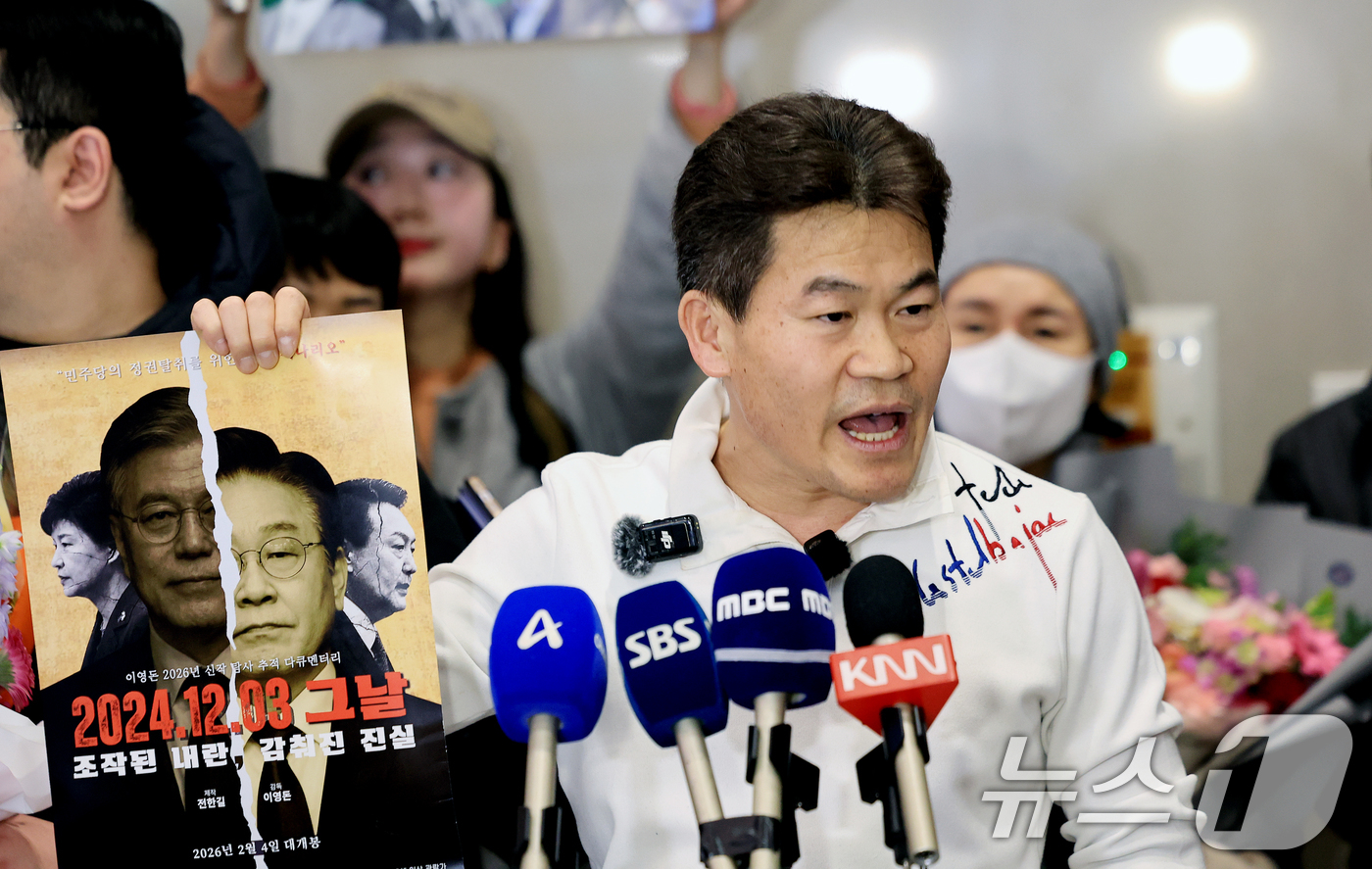 (인천공항=뉴스1) 이호윤 기자 = 전한길 전 한국사 강사가 3일 인천국제공항 제2여객터미널로 귀국해 기자회견에서 자신이 제작한 영화 포스터를 들어보이고 있다. 2026.2.3/뉴 …