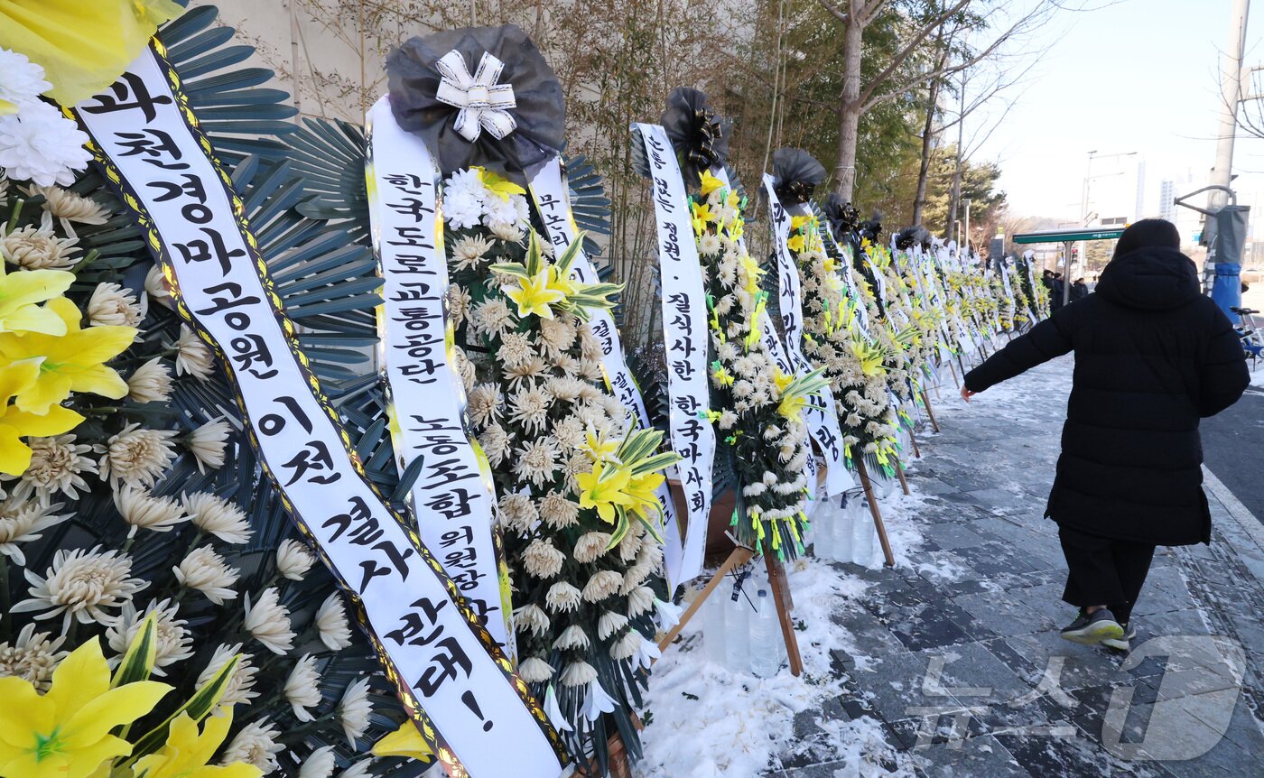 본문 이미지 - 정부가 과천 경마공원 이전 및 9,800호 주택 공급 계획을 지난달 29일 발표한 가운데 3일 세종시 정부세종청사 국토교통부 앞에 경마공원 이전 결정 철회 등을 요구하는 조화가 줄지어 서 있다. 2026.2.3 ⓒ 뉴스1 김기남 기자