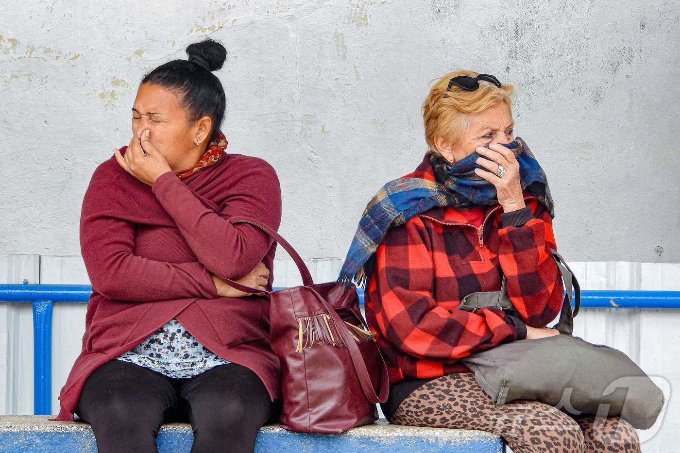 본문 이미지 - 3일 쿠바 수도 아바나에서 버스를 기다리는 여성들이 추위를 피해 얼굴을 가리고 있다. 2026.02.03 ⓒ AFP=뉴스1 ⓒ News1 최종일 선임기자