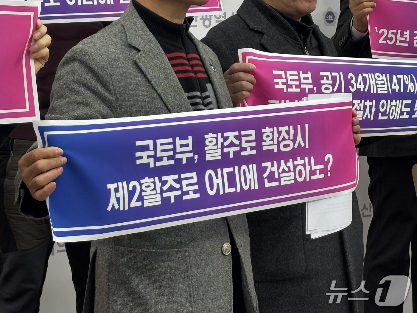 본문 이미지 - 4일 진행된 기자회견에서 한 참석자가 장래 확장성을 고려한 배치계획 조정 검토를 촉구하는 피켓을 들고 있는 모습 2026.02.04/뉴스1 ⓒ News1 홍윤 기자