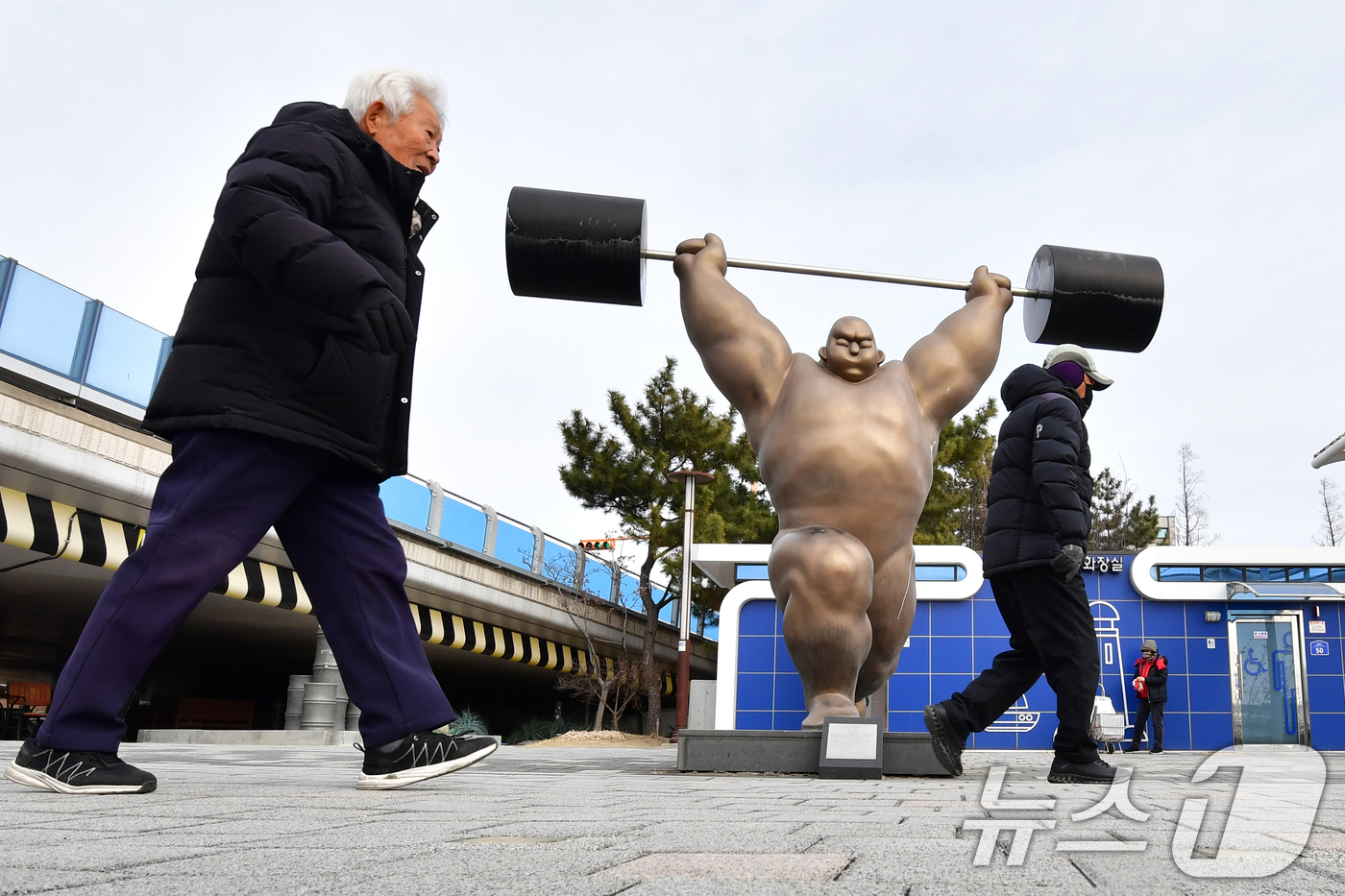 (포항=뉴스1) 최창호 기자 = 절기상 입춘인 4일 오후 경북 포항시 송도동 포항운하 도로에 설치된 역도 조형물 앞으로 시민들이 걸어가고 있다. 2026.2.4/뉴스1