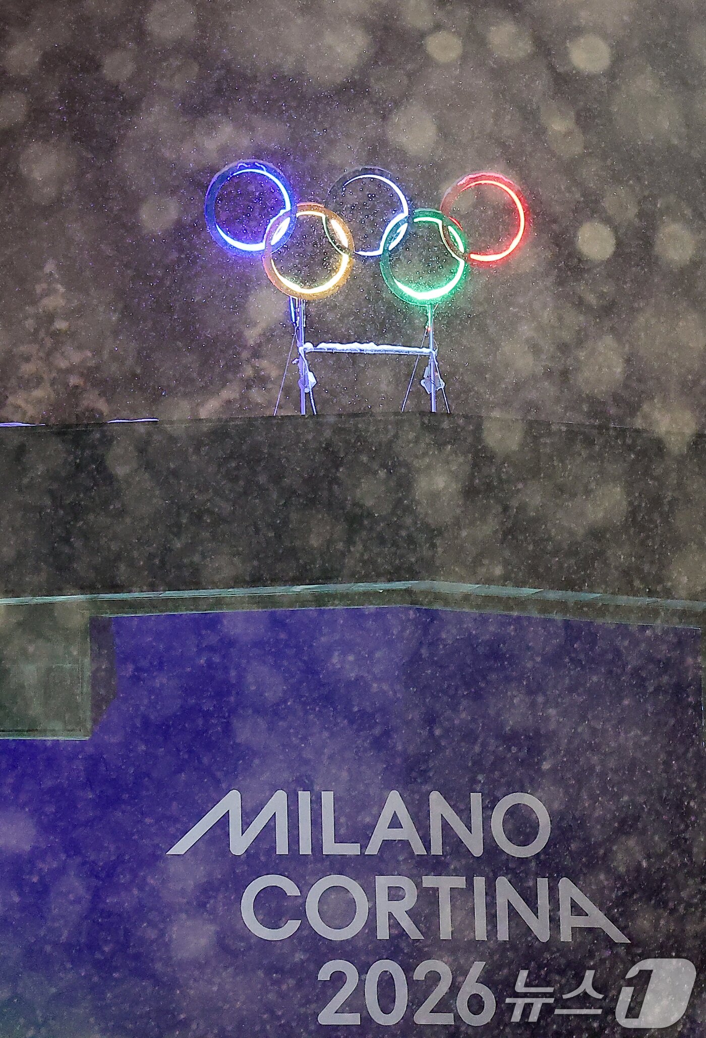 본문 이미지 - 2026 밀라노·코르티나담페초 동계올림픽 개막을 이틀 앞둔 4일(현지시간) 이탈리아 코르티나담페초 컬링 올림픽 스타디움에 설치된 올림픽 오륜기 조형물 뒤로 함박눈이 내리고 있다. 2026.2.5/뉴스1 ⓒ News1 김성진 기자