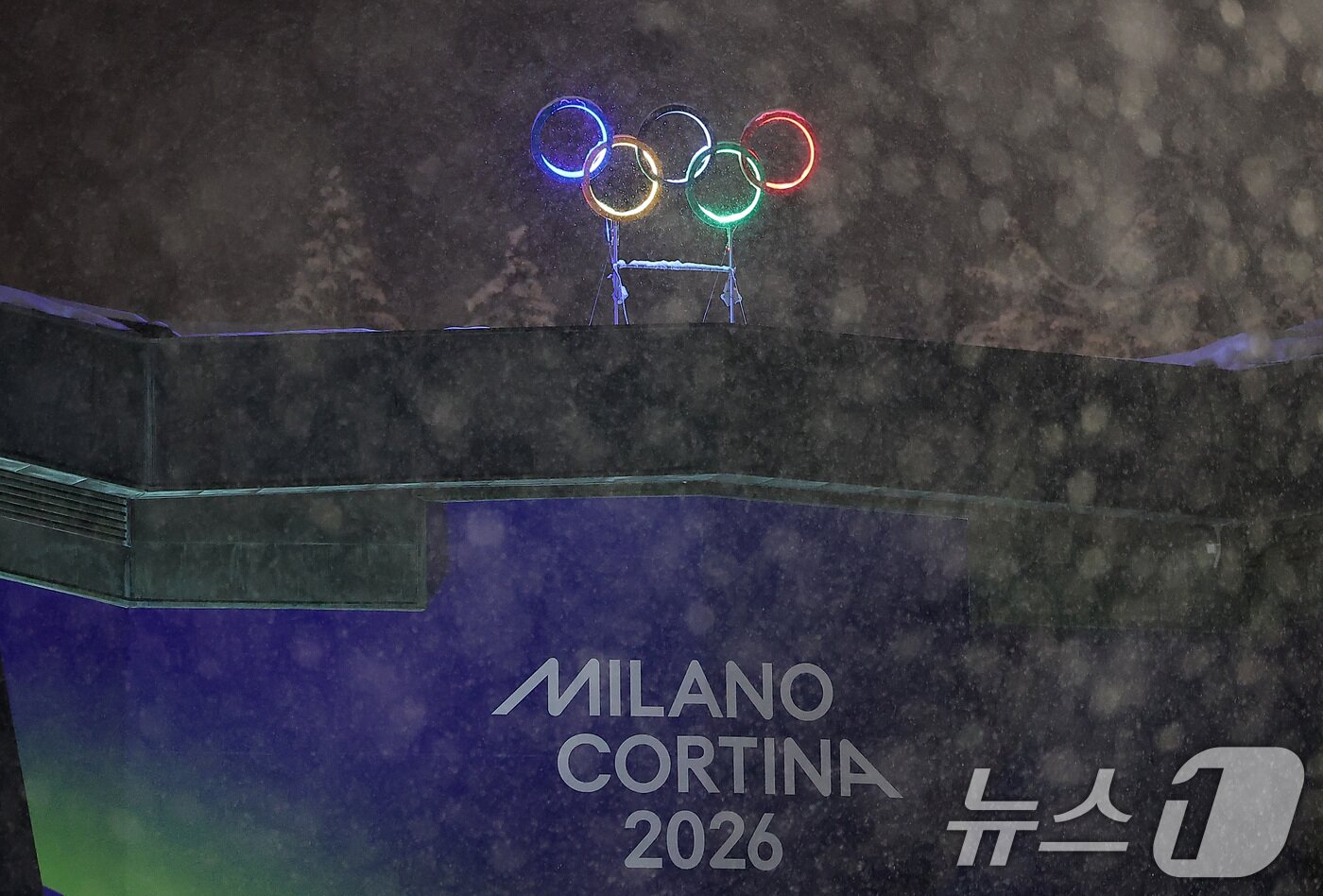 본문 이미지 - 2026 밀라노·코르티나담페초 동계올림픽 개막을 이틀 앞둔 4일(현지시간) 이탈리아 코르티나담페초 컬링 올림픽 스타디움에 설치된 올림픽 오륜기 조형물 뒤로 함박눈이 내리고 있다. 2026.2.5/뉴스1 ⓒ News1 김성진 기자