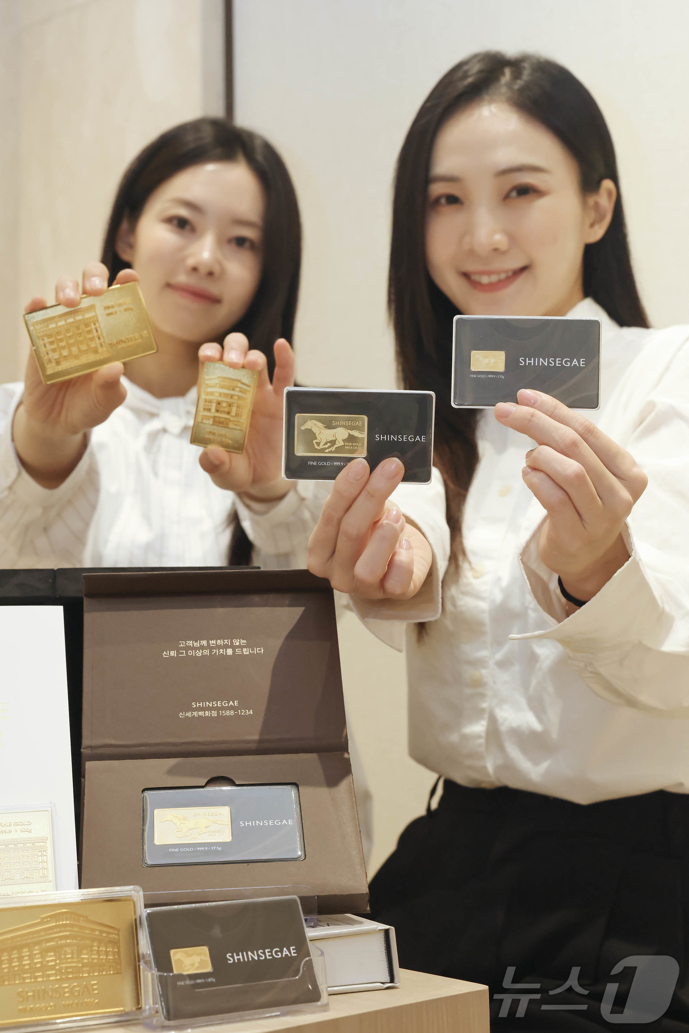 (서울=뉴스1) = 신세계백화점이 병오년 새해를 맞아 명절 선물 세트로 골드바를 선보인다고 5일 밝혔다. 사진은 모델들이 신세계백화점 본점 컨시어지 데스크에서 신세계 골드바를 소개 …