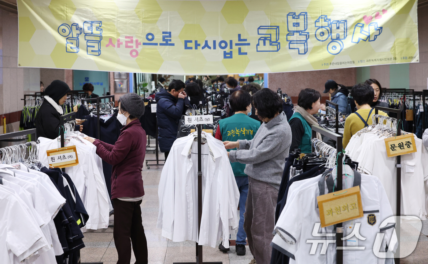 (과천=뉴스1) 김영운 기자 = 5일 경기 과천시 과천시민회관 녹색가게 앞 로비에서 열린 '제29회 알뜰사랑으로 물려입는 교복 행사'에서 학부모들이 기부된 과천시 관내 중·고등학교 …