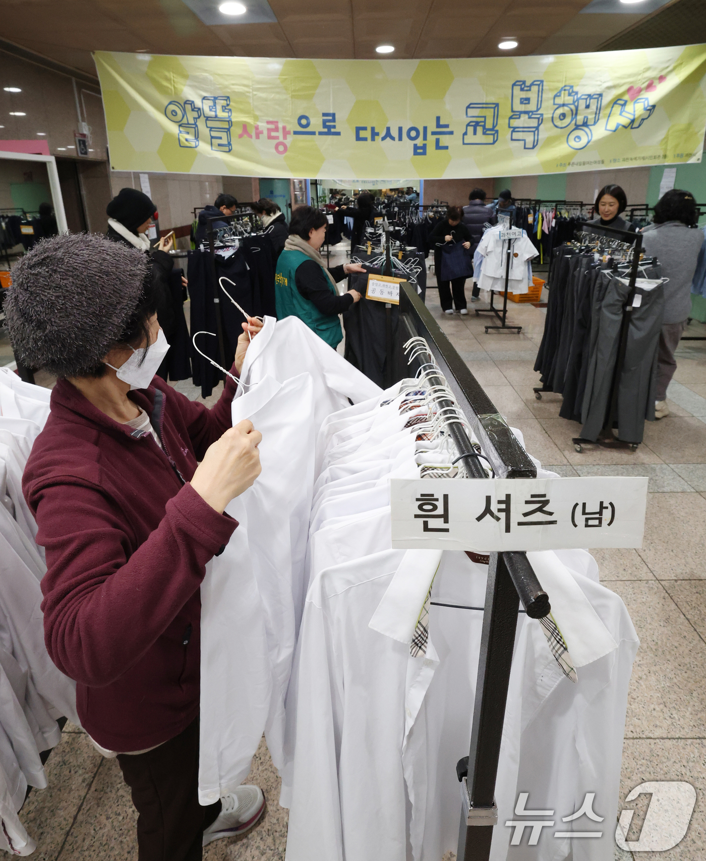 (과천=뉴스1) 김영운 기자 = 5일 경기 과천시 과천시민회관 녹색가게 앞 로비에서 열린 '제29회 알뜰사랑으로 물려입는 교복 행사'에서 학부모들이 기부된 과천시 관내 중·고등학교 …