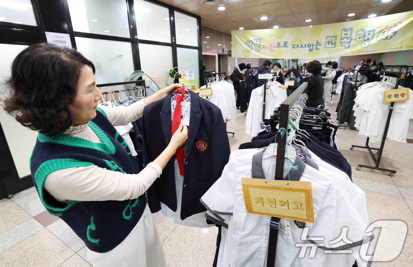 (과천=뉴스1) 김영운 기자 = 5일 경기 과천시 과천시민회관 녹색가게 앞 로비에서 열린 '제29회 알뜰사랑으로 물려입는 교복 행사'에서 학부모들이 기부된 과천시 관내 중·고등학교 …