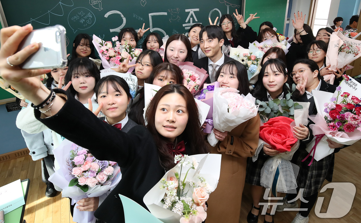 (대구=뉴스1) 공정식 기자 = 5일 오전 대구 달서구 송현여고 제44회 졸업식을 마친 졸업생들이 고3 교실에서 담임 선생님과 마지막 기념사진을 남기고 있다. 2026.2.5/뉴스 …