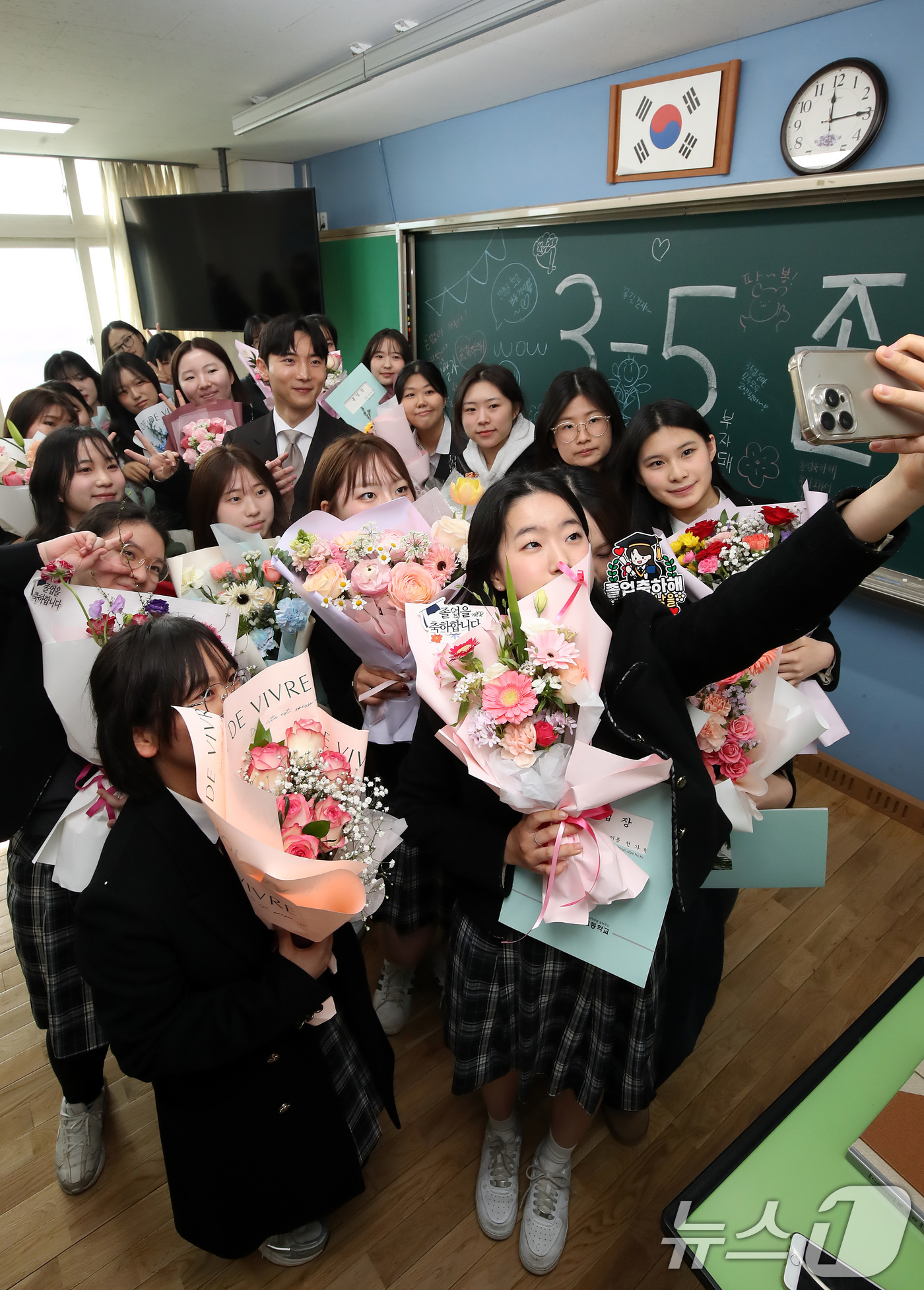 (대구=뉴스1) 공정식 기자 = 5일 오전 대구 달서구 송현여고 제44회 졸업식을 마친 졸업생들이 고3 교실에서 담임 선생님과 마지막 기념사진을 남기고 있다. 2026.2.5/뉴스 …