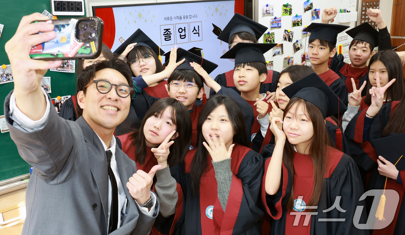 (서울=뉴스1) 이호윤 기자 = 6일 서울 은평구 서울신도초등학교에서 열린 졸업식에서 학생들이 담임선생님과 기념촬영을 하고 있다. 2026.2.6/뉴스1