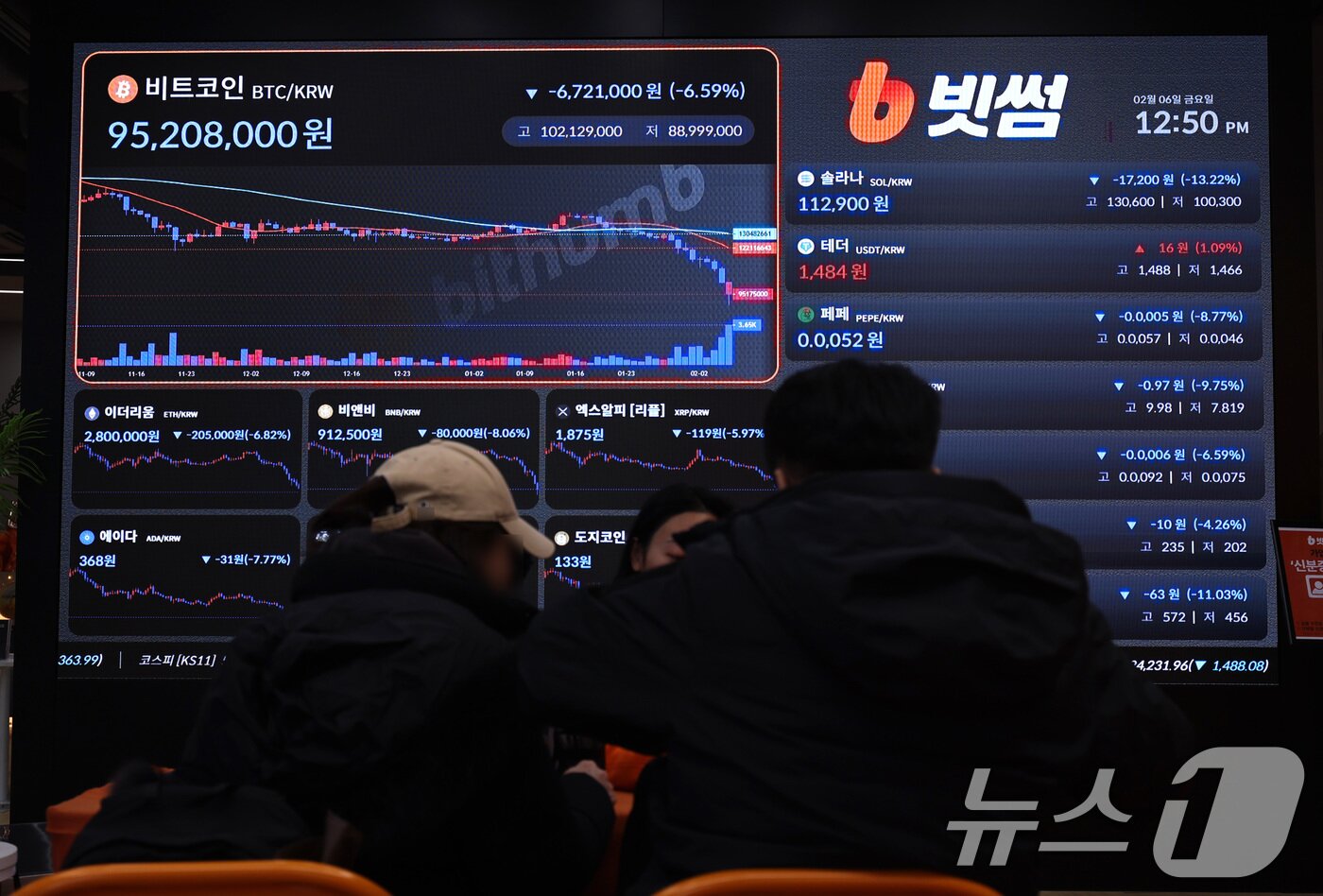 본문 이미지 - 6일 서울 강남구 빗썸 라운지에 설치된 암호화폐 시세 현황판 앞에서 방문객들이 계좌 개설 상담을 받고 있다. 이날 비트코인 1개의 가격은 종가 기준 2024년 10월 말 이후 최저 수준인 6만6060달러를 기록했다. 2026.2.6 ⓒ 뉴스1 구윤성 기자