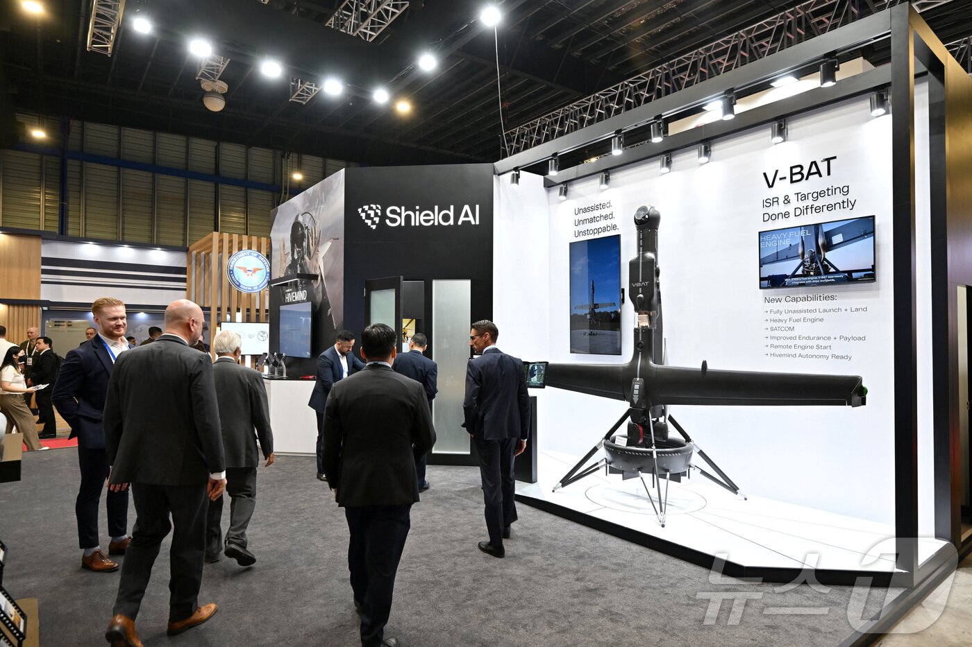 본문 이미지 - 3일(현지시간) '싱가포르 에어쇼 2026'이 개최되고 있는 싱가포르 창이 전시센터에서 사람들이 미국의 차세대 방산 기업인 '쉴드 AI'(Shield AI)의 부스를 지나가고 있다. 2026.02.03 ⓒ 로이터=뉴스1