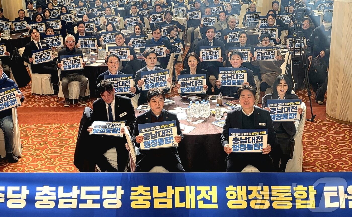 본문 이미지 - 6일 충남 아산시 온양관광호텔 크리스탈볼룸홀에서 열린 더불어민주당 충남도당 주최 충남대전통합 타운홀 미팅에서 참석자들이 행정통합을 촉구하는 손피켓을 들고 기념 촬영하고 있다. 2026.2.6 / ⓒ 뉴스1 이시우 기자