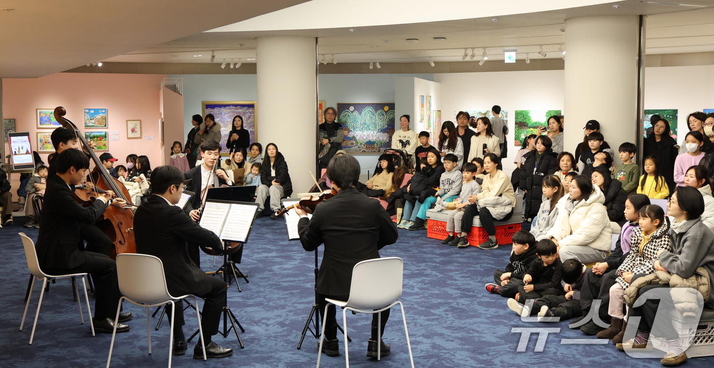 (수원=뉴스1) 김영운 기자 = 6일 경기 수원시 영통구 경기도서관 힙플레이스에서 열린 '예술로 소통하다' 특별공연에서 시민들이 경기리베라오케스트라의 아름다운 현악 5중주 연주를 …