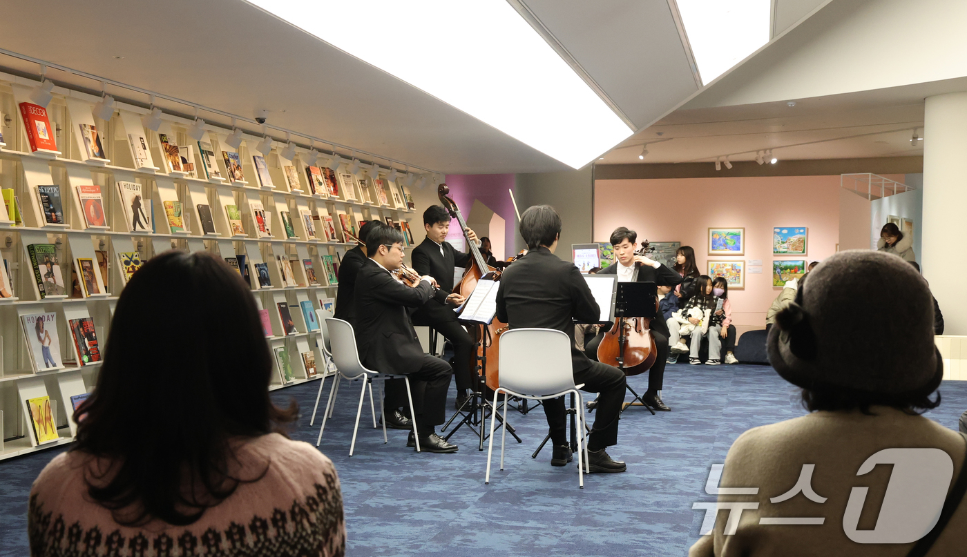 (수원=뉴스1) 김영운 기자 = 6일 경기 수원시 영통구 경기도서관 힙플레이스에서 열린 '예술로 소통하다' 특별공연에서 시민들이 경기리베라오케스트라의 아름다운 현악 5중주 연주를 …