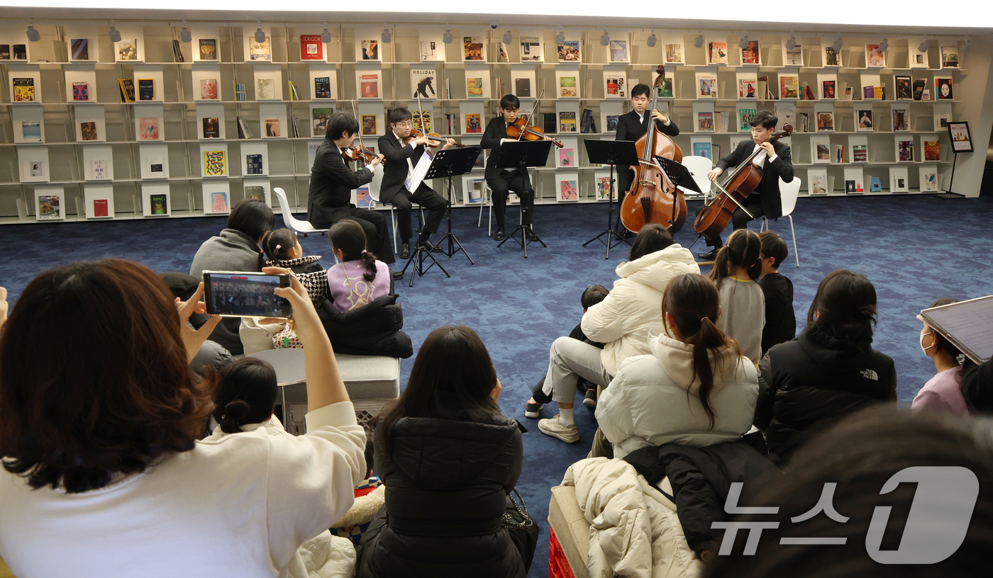 (수원=뉴스1) 김영운 기자 = 6일 경기 수원시 영통구 경기도서관 힙플레이스에서 열린 '예술로 소통하다' 특별공연에서 시민들이 경기리베라오케스트라의 아름다운 현악 5중주 연주를 …