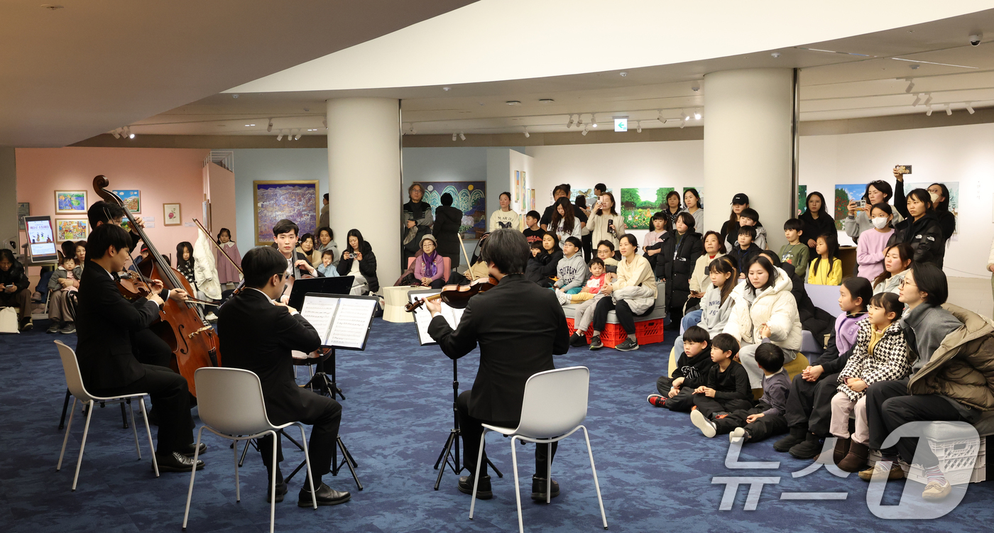 (수원=뉴스1) 김영운 기자 = 6일 경기 수원시 영통구 경기도서관 힙플레이스에서 열린 '예술로 소통하다' 특별공연에서 시민들이 경기리베라오케스트라의 아름다운 현악 5중주 연주를 …