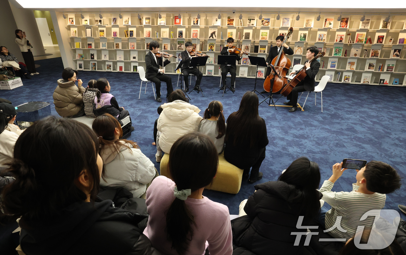 (수원=뉴스1) 김영운 기자 = 6일 경기 수원시 영통구 경기도서관 힙플레이스에서 열린 '예술로 소통하다' 특별공연에서 시민들이 경기리베라오케스트라의 아름다운 현악 5중주 연주를 …