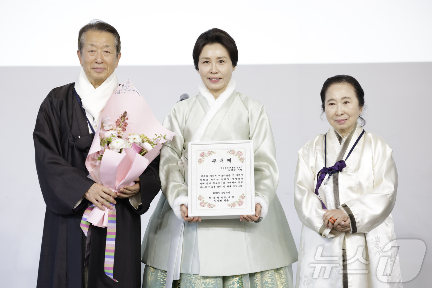 (서울=뉴스1) 이재명 기자 = 김혜경 여사가 6일 서울 중구 정동1928 아트센터에서 열린 2026 설맞이 한복인 신년회에서 한복 명예홍보대사 추대패를 전달받은 뒤 정순훈 한복세 …