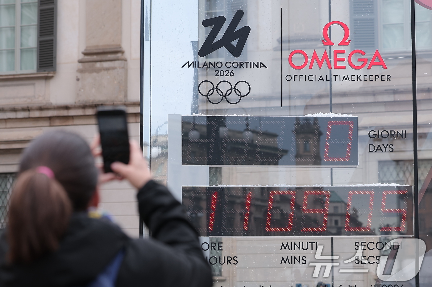 (밀라노=뉴스1) 김성진 기자 = 2026 밀라노·코르티나 동계올림픽 개막일인 6일(현지시간) 이탈리아 밀라노 두오모 광장 인근에서 관광객이 올림픽 개막시간을 알리는 조형물을 스마 …