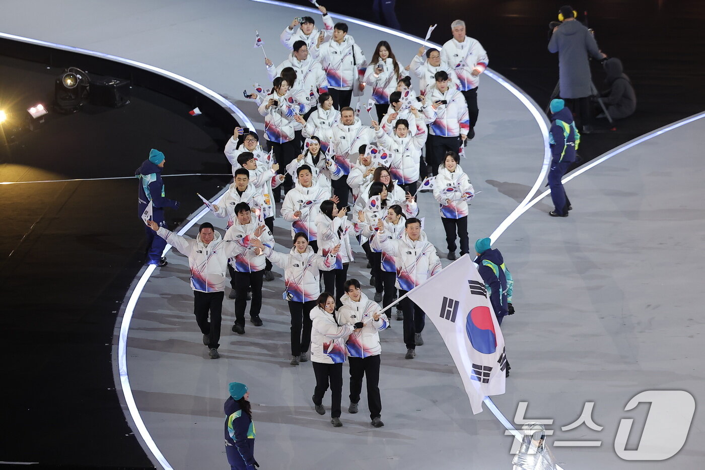 본문 이미지 - 대한민국 선수단 기수 차준환(피겨 스케이팅)과 박지우(스피드 스케이팅)가 6일 오후(현지시간) 이탈리아 밀라노 산시로 올림픽 스타디움에서 열린 2026 밀라노·코르티나담페초 동계올림픽대회 개회식에서 선수단을 이끌고 입장하고 있다. 2026.2.7 ⓒ 뉴스1 김성진 기자