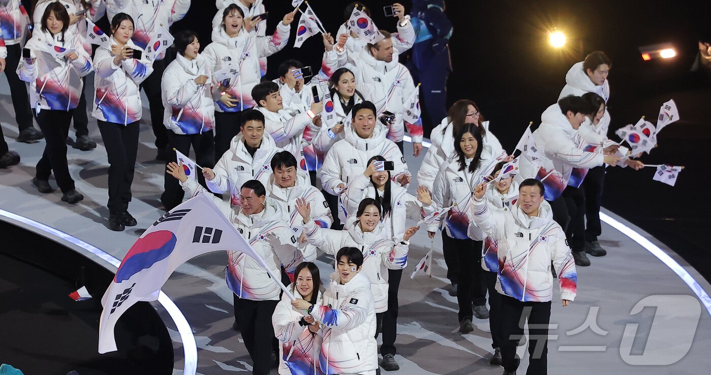 본문 이미지 - 대한민국 선수단 기수 차준환(피겨 스케이팅)과 박지우(스피드 스케이팅)가 6일 오후(현지시간) 이탈리아 밀라노 산시로 올림픽 스타디움에서 열린 2026 밀라노·코르티나담페초 동계올림픽대회 개회식에서 선수단을 이끌고 입장하고 있다. 2026.2.7 ⓒ 뉴스1 김성진 기자