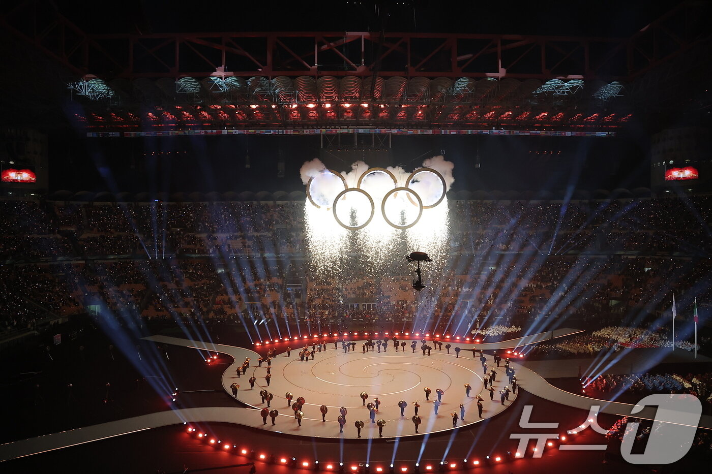 본문 이미지 - 6일 오후(현지시간) 이탈리아 밀라노 산시로 올림픽 스타디움에서 열린 2026 밀라노·코르티나담페초 동계올림픽대회 개회식에서 이탈리아 알파인 스킨 레전드 데보라 콤파뇨니, 엘베르토 톰바가 성화를 점화하자 오륜기 로고 조형물에서 불꽃이 터지고 있다. 2026.2.7 ⓒ 뉴스1 김성진 기자