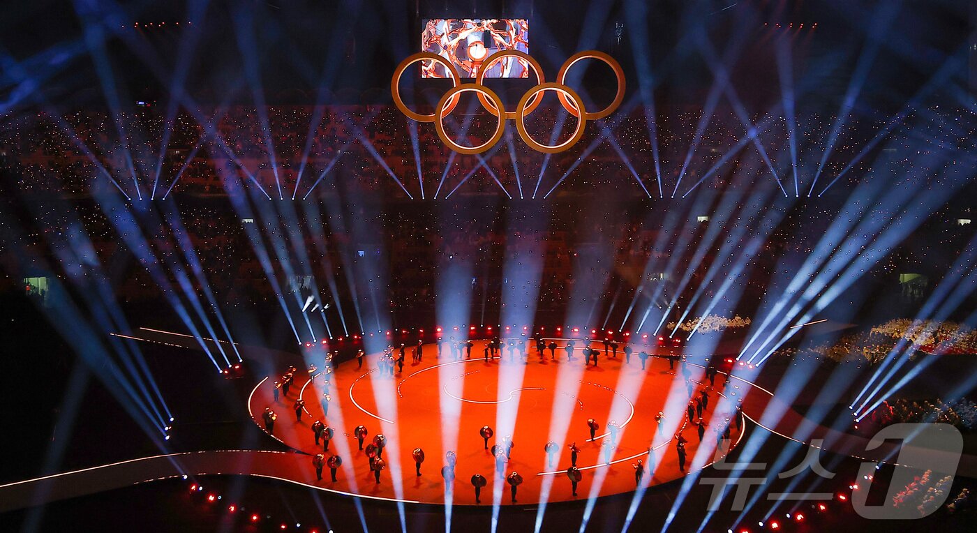 본문 이미지 - 6일 오후(현지시간) 이탈리아 밀라노 산시로 올림픽 스타디움에서 열린 2026 밀라노·코르티나담페초 동계올림픽대회 개회식에서 이탈리아 알파인 스킨 레전드 데보라 콤파뇨니, 엘베르토 톰바가 성화를 점화하자 오륜기 로고 조형물에서 불꽃이 터지고 있다. 2026.2.7 ⓒ 뉴스1 김성진 기자