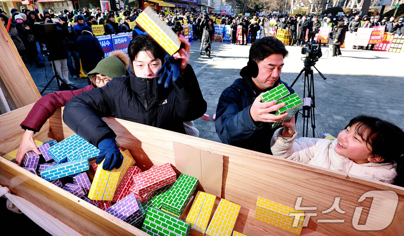 본문 이미지 - 과천경마공원 이전 반대 비상대책위원회와 과천 시민들이 7일 경기 과천시 중앙공원 분수대 앞에서 열린 '과천경마공원 이전 반대 집회'에서 벽돌을 던지며 퍼포먼스를 하고 있다.  2026.2.7 ⓒ 뉴스1 이호윤 기자