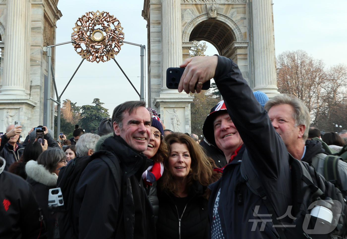 (밀라노=뉴스1) 김진환 기자 = 7일(현지시간) 오후 이탈리아 밀라노 '평화의 아치'(아르코 델라 파체·Arco della Pace) 성화대를 찾은 영국 관광객들이 타오르는 성화 …