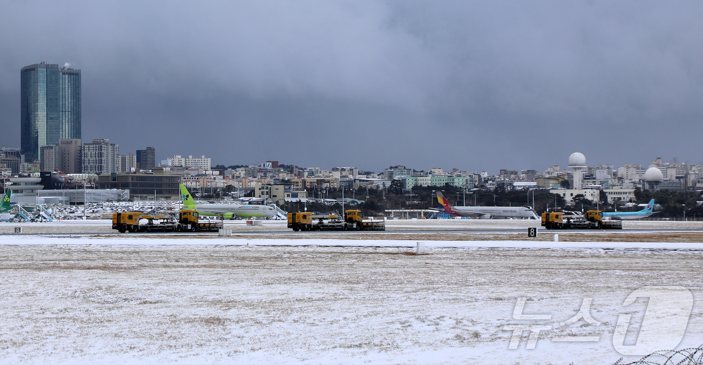 (제주=뉴스1) 오미란 기자 = 8일 오전 강한 눈폭풍으로 활주로 운영이 중단된 제주국제공항에서 제설차들이 분주히 오가고 있다. 2026.2.8/뉴스1