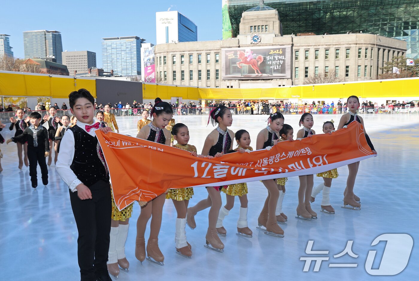 본문 이미지 - 겨울철 서울 도심 대표 명소로 자리매김한 서울광장 스케이트장이 폐장한 8일 오후 스케이트장 메인링크에서 리라피겨그룹 선수들이 피날레 공연을 마친 후 현수막을 들고 인사하고 있다. 2026.2.8 ⓒ 뉴스1 오대일 기자