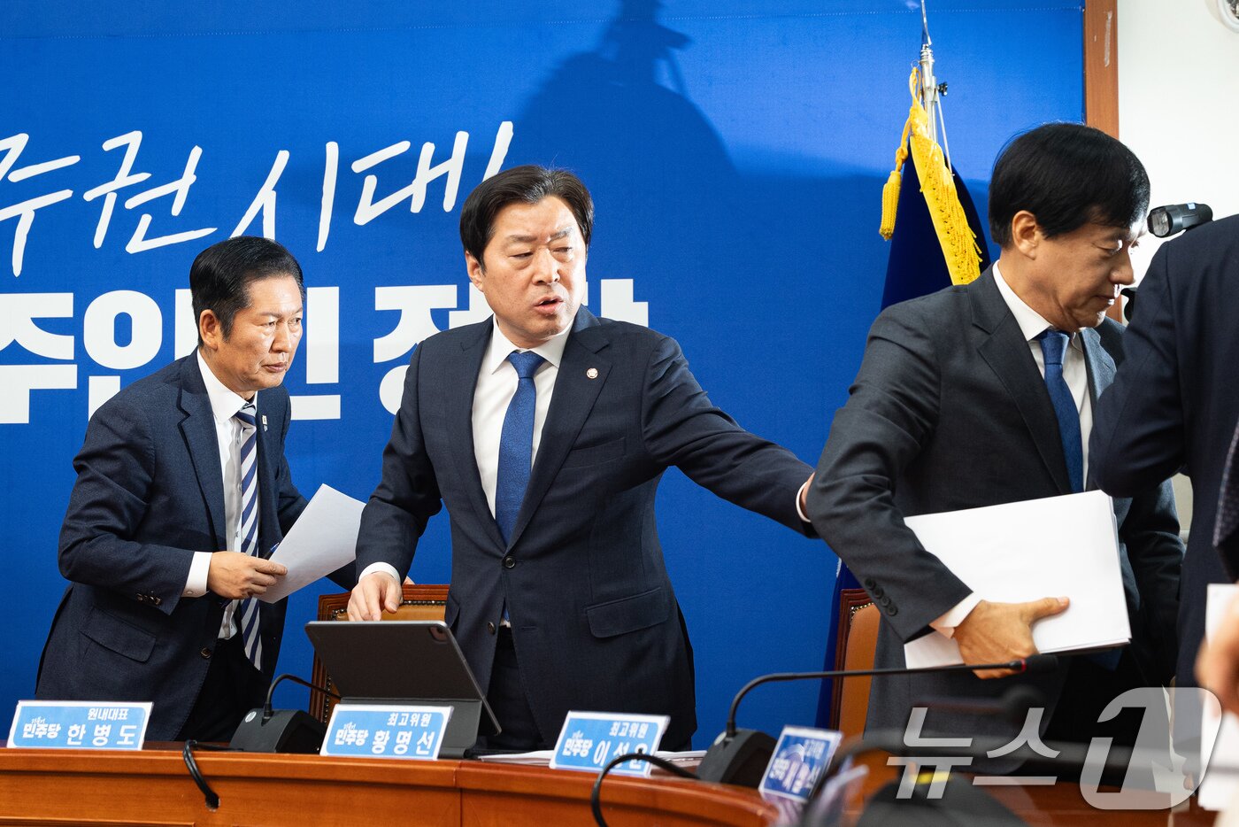 본문 이미지 - 황명선 더불어민주당 최고위원이 9일 서울 여의도 국회에서 열린 공개 최고위원회의를 마친 후 나서는 이성윤 최고위원을 붙잡고 있다. 왼쪽은 정청래 대표. 2026.2.9 ⓒ 뉴스1 유승관 기자