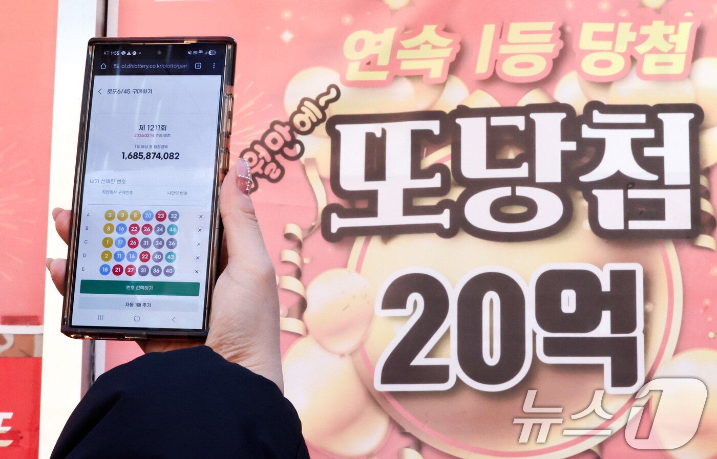 본문 이미지 - 모바일 로또 판매가 시작된 9일 서울 시내의 한 복권 판매점 앞에서 시민이 휴대폰으로 로또를 구매하고 있다. 2026.2.9 ⓒ 뉴스1 최지환 기자