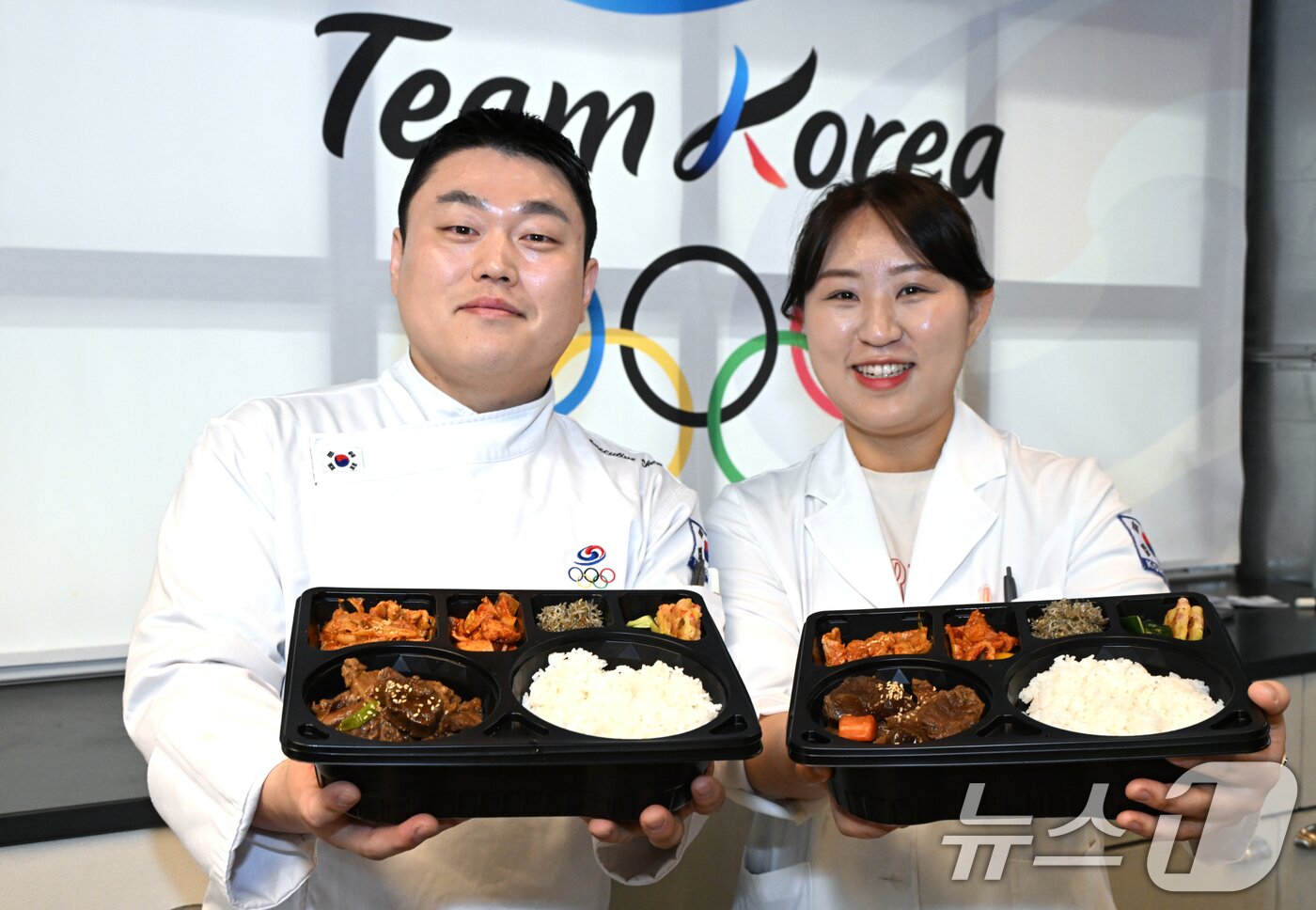 본문 이미지 - 9일(현지시간) 이탈리아 밀라노에서 열린 대한체육회가 운영하는 급식지원센터 공개 미디어행사에서 김중현 조리장과 조은영 영양사가 국가대표팀 선수들에게 전달한 도시락을 들고 포즈를 취하고 있다. (대한체육회 제공. 재판매 및 DB 금지) 2026.2.9 ⓒ 뉴스1 김명섭 기자